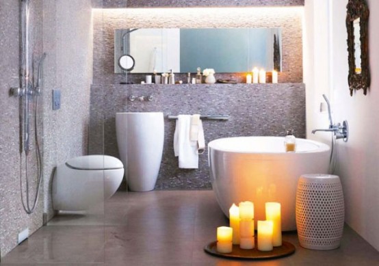 un bagno moderno e rilassante con pavimento in pietra, elettrodomestici eleganti dall'aspetto curvo, una mensola e uno specchio sopra