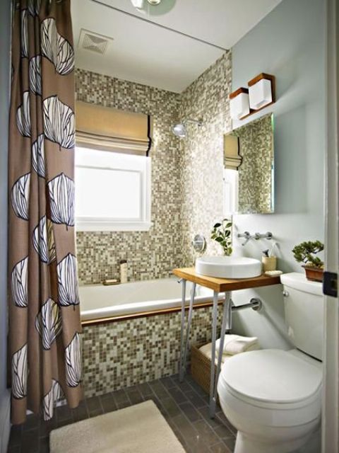 un piccolo bagno accattivante con tessere di mosaico, vetro smerigliato, una vanità su gambe a forcina e una tenda stampata