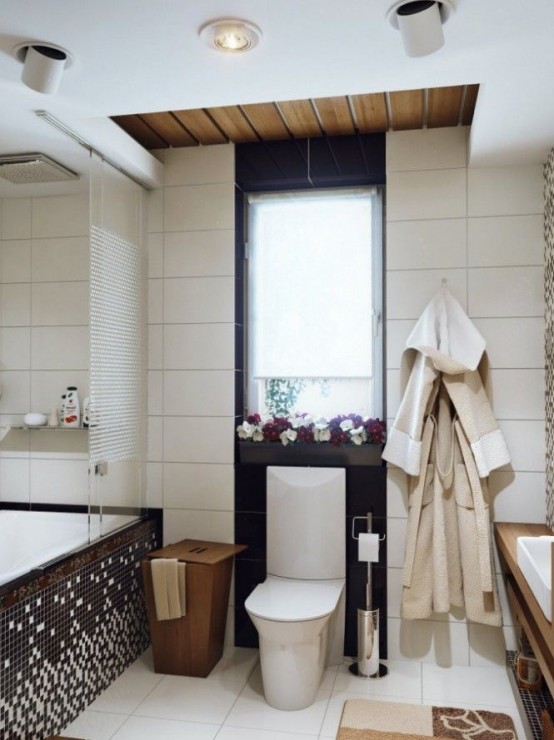 un bagno moderno con piastrelle bianche e nere, un lavabo in legno galleggiante, una vasca rivestita con tessere di mosaico e un secchio di legno