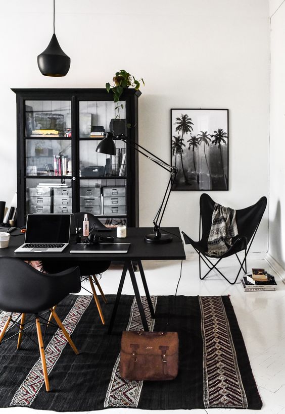 un bizzarro ufficio in bianco e nero con mobili neri, bianchi come una tela bianca e arte in bianco e nero