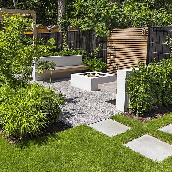 un giardino minimalista con un prato, ciottoli, piastrelle, mobili minimalisti, molta vegetazione tutt'intorno