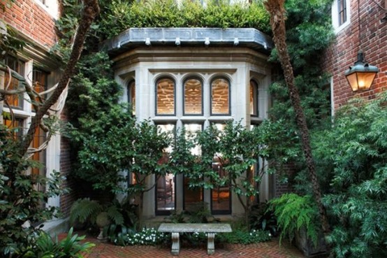 un piccolo giardino terratetto fatto con mattoni e verde piantumato di vario genere