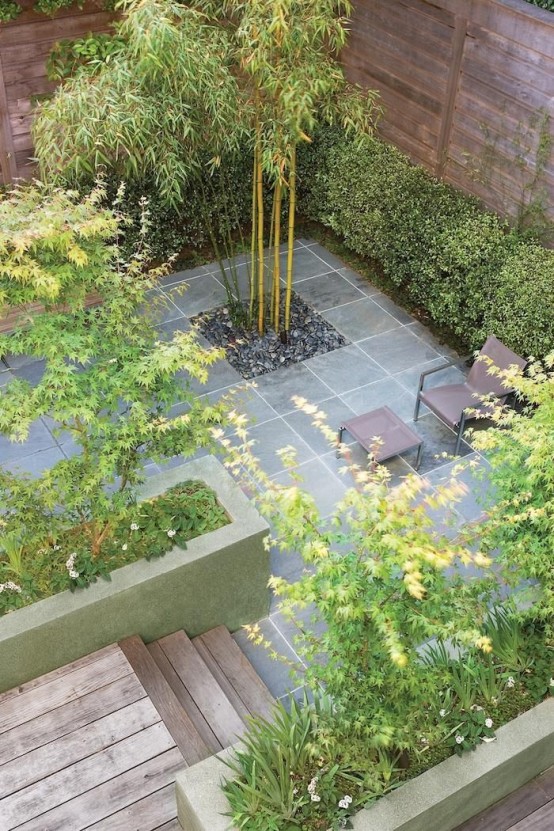 un giardino in una casa a schiera minimalista con piastrelle in pietra, alberi e vegetazione oltre ad alcuni mobili moderni
