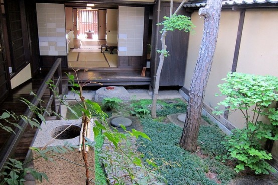 un giardino zen townhoue con vegetazione, un albero, pietre e rocce ispirato all'estetica tradizionale giapponese