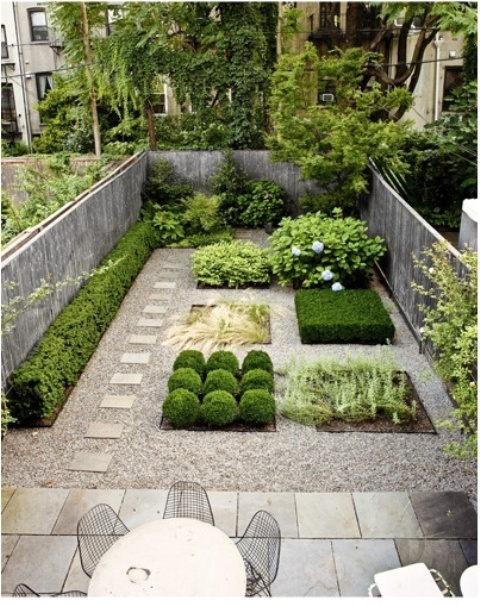 un giardino in una casa a schiera minimalista con piastrelle in pietra, ciottoli, piante eleganti senza aiuole e un set da pranzo