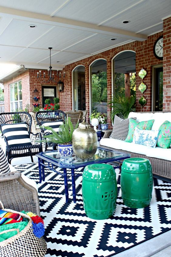 un patio super colorato intorno a un tavolino da caffè in vetro blu con varie opzioni di posti a sedere non corrispondenti