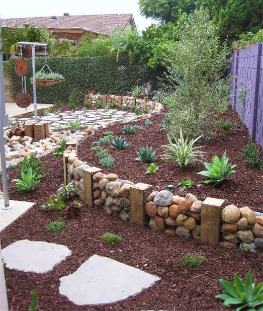 un muro di gabbioni utilizzato come bordo del giardino si fonde con l'ambiente naturale rendendolo fresco e fresco