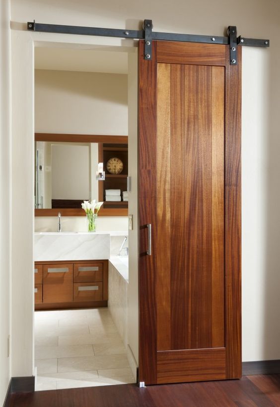una porta scorrevole in legno aggiunge un tocco rustico chic allo spazio e si abbina agli armadi