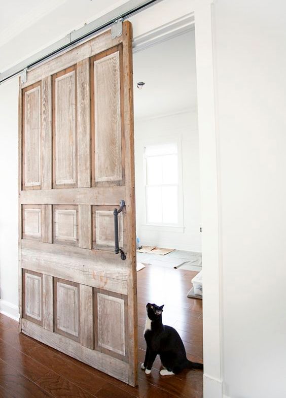 una porta scorrevole vintage in legno con maniglie aggiunge un tocco raffinato allo spazio