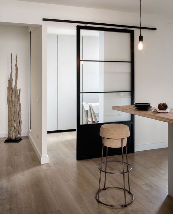 una porta scorrevole nera con vetri è l'ideale per uno spazio minimalista o scandinavo