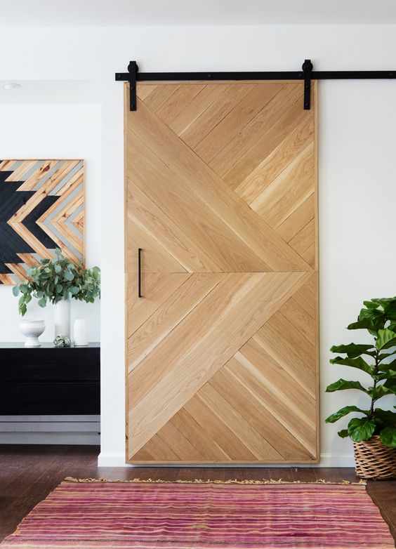una porta scorrevole in legno geometrica aggiunge un tocco rustico ma moderno allo spazio