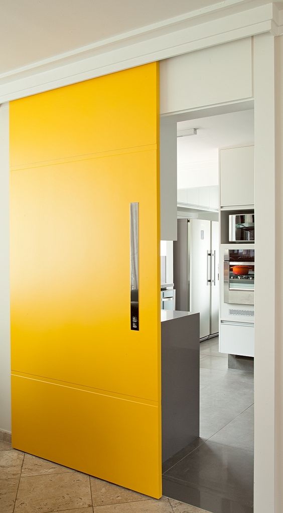 una porta scorrevole giallo brillante aggiunge colore allo spazio e lo rende più fresco