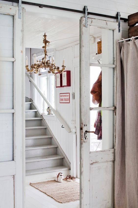 una porta scorrevole vintage imbiancata aggiunge eleganza allo spazio che separa delicatamente gli spazi