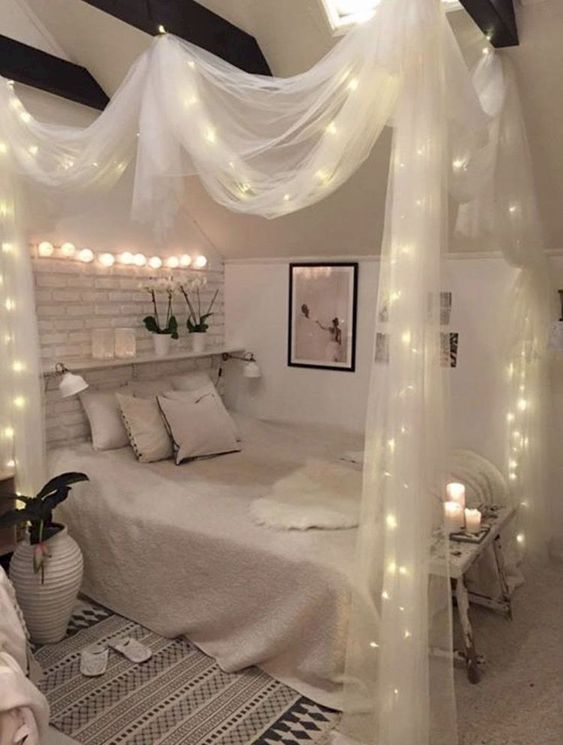 baldacchino in tessuto trasparente con luci e luci sopra il letto per un look chic e romantico