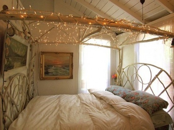 una cornice di rami con luci sospese sul letto per un'atmosfera rilassata e boho