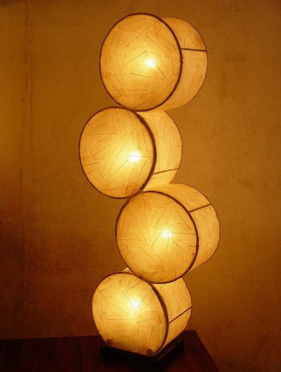 una lampada da tavolo unica fatta di grandi tamburi trasparenti e luci all'interno