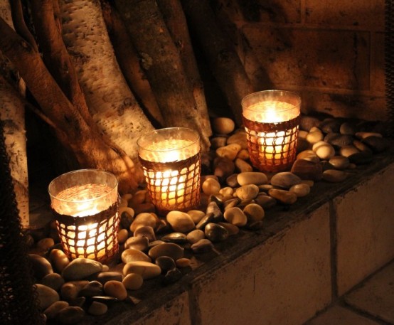 un vassoio con ciottoli e portacandele in vetro con candele per un tocco naturale