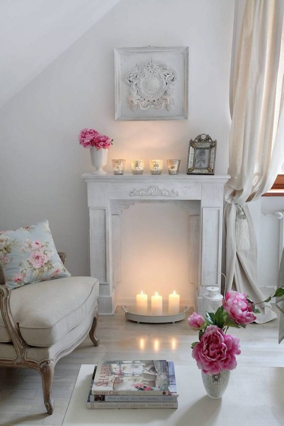 un romantico caminetto vintage imbiancato a calce con un piccolo vassoio di metallo con tre candele