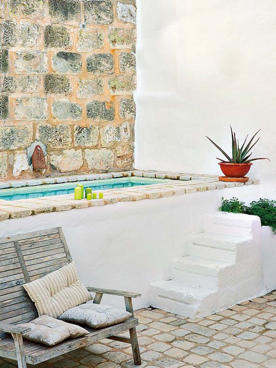 un bel bagno esterno mediterraneo con scale, fioriere, mattoni e una panca shabby chic