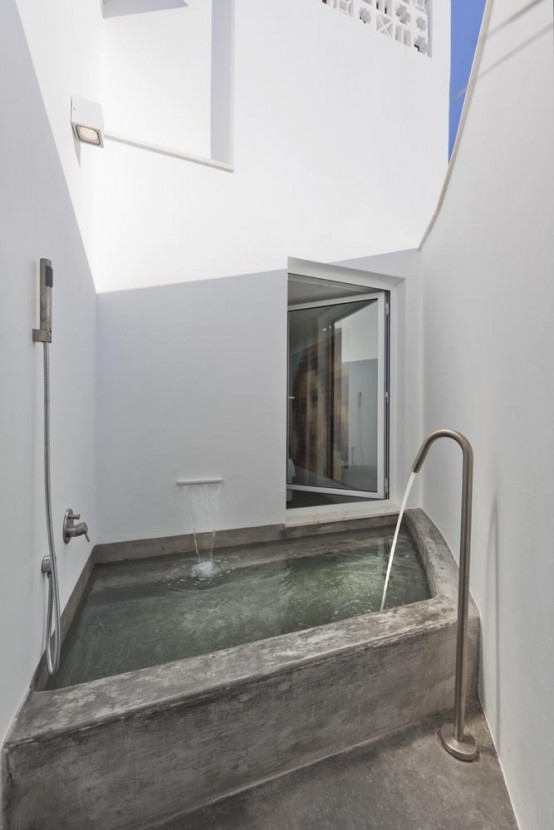 un bagno esterno minimalista con vasca da bagno incorporata e semplici pareti bianche