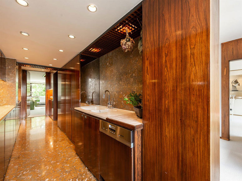 La cucina è realizzata con mobili moderni in legno dai colori intensi e superfici in pietra qua e là