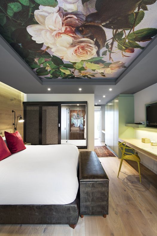 una camera da letto con uno splendido soffitto floreale realistico che aggiunge romanticismo e un tocco raffinato allo spazio moderno