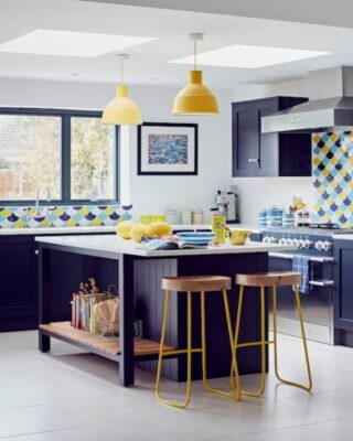 una cucina luminosa e allegra realizzata in audace blu e giallo sole, con piastrelle in scala accattivante e superfici bianche per un aggiornamento