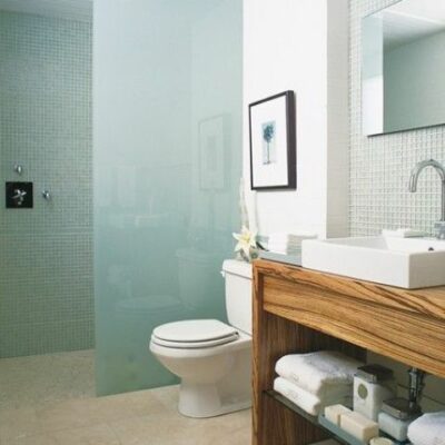 un bagno moderno con uno spazio doccia fatto con piastrelle blu e vetro smerigliato blu per un look fresco