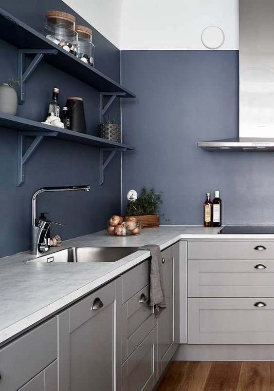 una cucina contemporanea audace in grigio chiaro con pareti e scaffali blu scuro sembra in definitiva spigolosa e chic