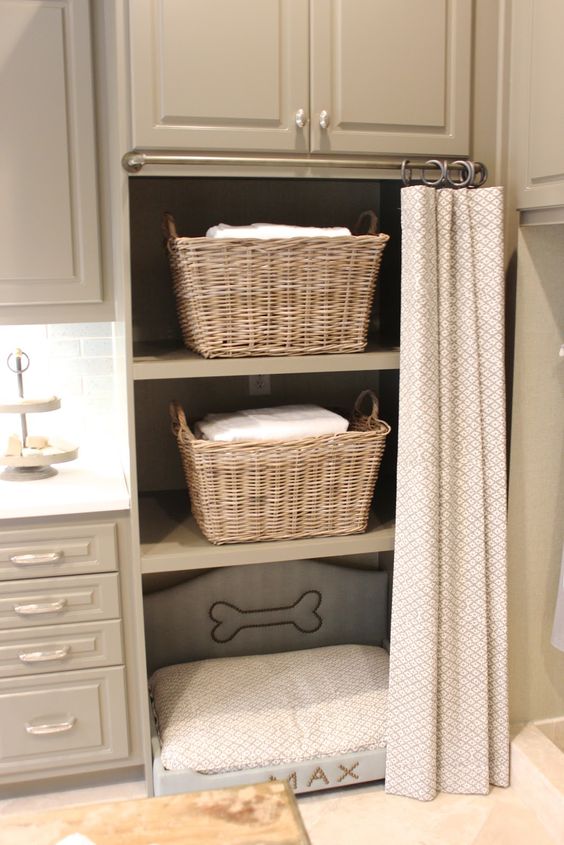 una lavanderia con armadietti e una cuccia incorporata per il tuo animale domestico per rilassarsi mentre fai le cose