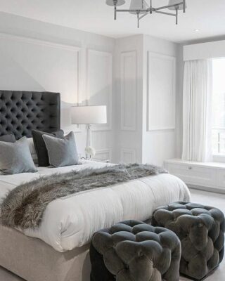 un paio di sgabelli trapuntati grigio grafite ai piedi del letto che si intonano al letto e ai tessuti