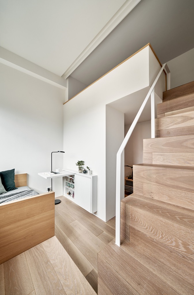 I progettisti hanno utilizzato il soffitto alto - 3,4 metri per creare due livelli nell'appartamento